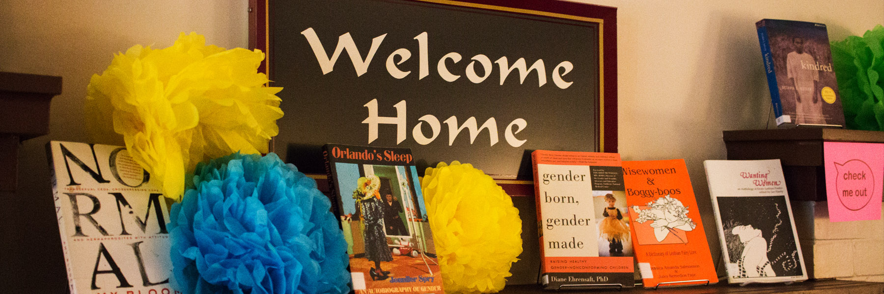 Picture of mantel at LGBTQ+ Center of frame text: welcome home